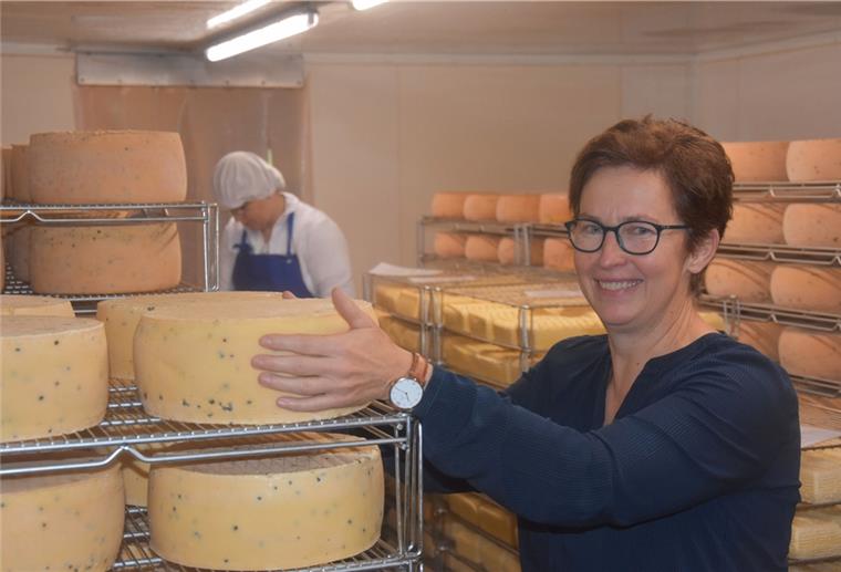 Frau steht in einem Lagerraum mit Käse.