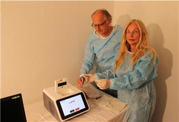 Apotheker Dr. Andreas Völsch und seine Frau Bärbel zeigen für unser Foto, wie das neue PCR-Testgerät funktioniert.
