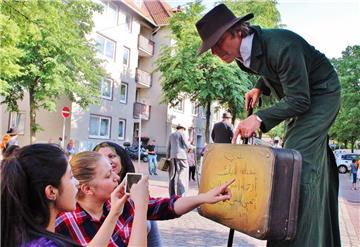 Arabische Buchstaben auf den Koffern der Auswanderer auf Stelzen erinnern die neuen Bewohner in der Goethestraße an ihre alte Heimat.