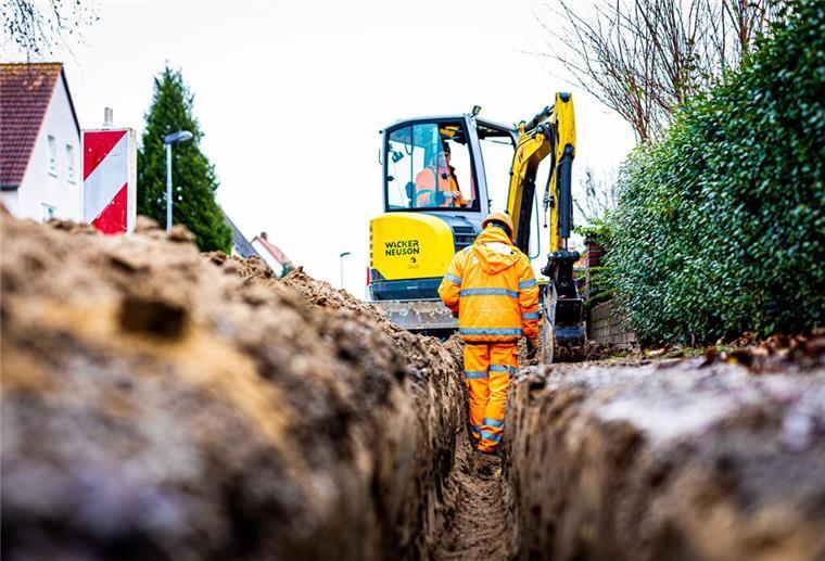 Wesermarsch: So steht es um den Breitbandausbau Arbeiter sind mit Bagger und Spaten an einer Straße mit der Erdverlegung von Glasfaserkabeln beschäftigt.