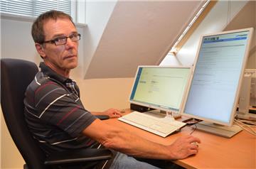 Arnold Baumann, Datenqualitätsmanager im Jobcenter, zeigt einen Arbeitsplatz. Ein zweiter hochkant aufgestellter Bildschirm soll das Gefühl vermitteln, in einer richtigen Akte zu lesen.