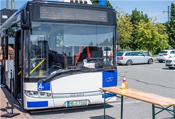 Bus auf Parkplatz mit Tisch davor.