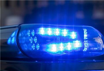 Das Blaulicht auf einem Fahrzeug der Polizei leuchtet in der Dunkelheit. 