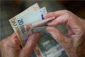Eine ältere Frau zählt Geld.