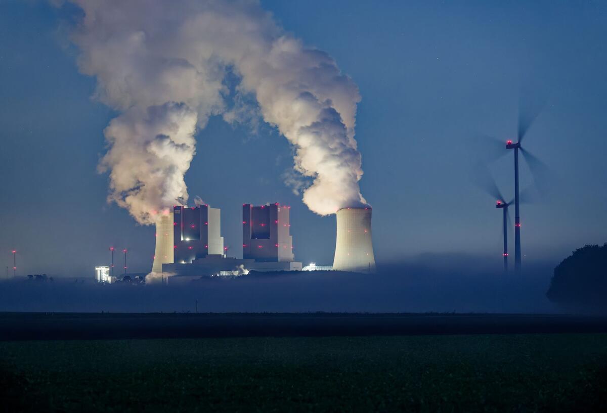 Dampf steigt von den Kühltürmen des Braunkohlekraftwerkes Neurath am frühen Morgen in den Himmel.