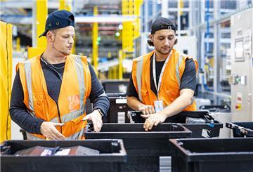 Mitarbeiter sortieren im neuen Logistikzentrum des Onlineversandhändlers Amazon in Helmstedt Boxen mit Produkten