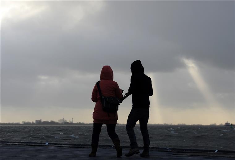 Achtung! Warnung vor schweren Sturmböen Gegen den starken Wind und die Sturmböen geht dieses junge Paar auf der Seebäderkaje in Bremerhaven.