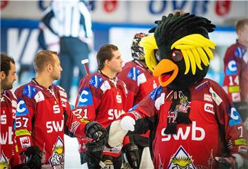 Maskottchen beim Eishockey klatscht Spieler ab