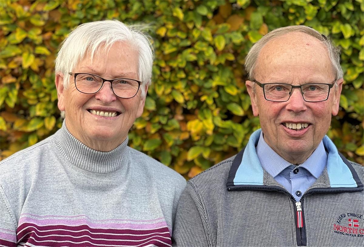 Mann und Frau vor einer Hecke.