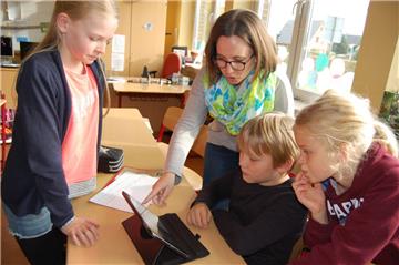 Auch wenn die Kinder – hier Laura, Benno und Mayla – keine Berührungsängste im Umgang mit den iPads haben und schon viel wissen, gibt ihnen Lehrerin Carina Neumann immer wieder hilfreiche Tipps.