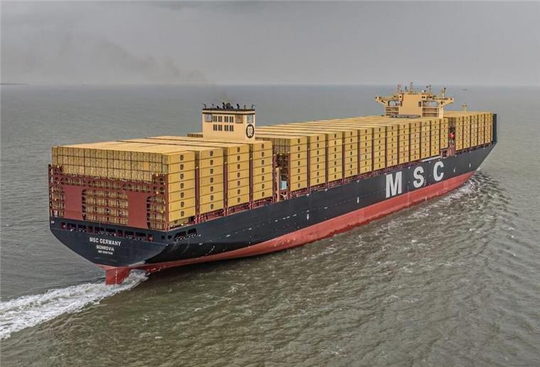Ein Containerschiff mit gelben Containern auf dem Meer.