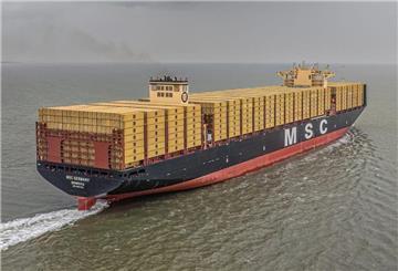 Ein Containerschiff mit gelben Containern auf dem Meer.