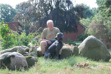 Auf den Findlingen vor seinem Bauernhaus genießt Hans-Georg Harrie mit dem Weimaraner-Rüden Pluto das Sommeridyll. Der Hof ist einer von fünfen, die früher die Bauernschaft am sogenannten Freien Damm Apeler bildeten. Foto Fixy