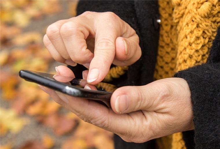 „Hallo Mama, mein Handy ist kaputt“ - Schiffdorferin riecht Lunte Frauenhände halten ein Handy und tippen auf den Bildschirm.