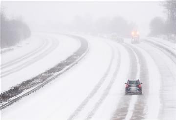 Ein Auto fährt bei Schneefall über die Autobahn A7.
