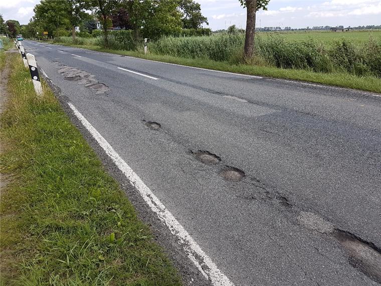 Schlaglöcher wegen Wesertunnel: Passiert hier noch mal was? Auf der Landesstraße 121 (Foto) und auf der Kreisstraße 50 sind durch die Umleitung des Verkehrs während der einmonatigen Bauzeit an den Zufahrten zum Wesertunnel Schäden entstanden. Einen Monat danach warten Anlieger und Autofahrer noch auf die Reparatur.