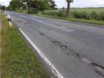 Auf der Landesstraße 121 (Foto) und auf der Kreisstraße 50 sind durch die Umleitung des Verkehrs während der einmonatigen Bauzeit an den Zufahrten zum Wesertunnel Schäden entstanden. Einen Monat danach warten Anlieger und Autofahrer noch auf die Reparatur. 