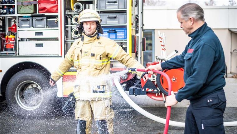 Auf der neuen hellen Kleidung sieht man den Schmutz, noch vor Ort wird er mit der mobilen Dusche abgewaschen: Nur zwei von vielen Maßnahmen bei der Feuerwehr, um die Einsatzkräfte vor giftigen Rußpartikeln zu schützen.