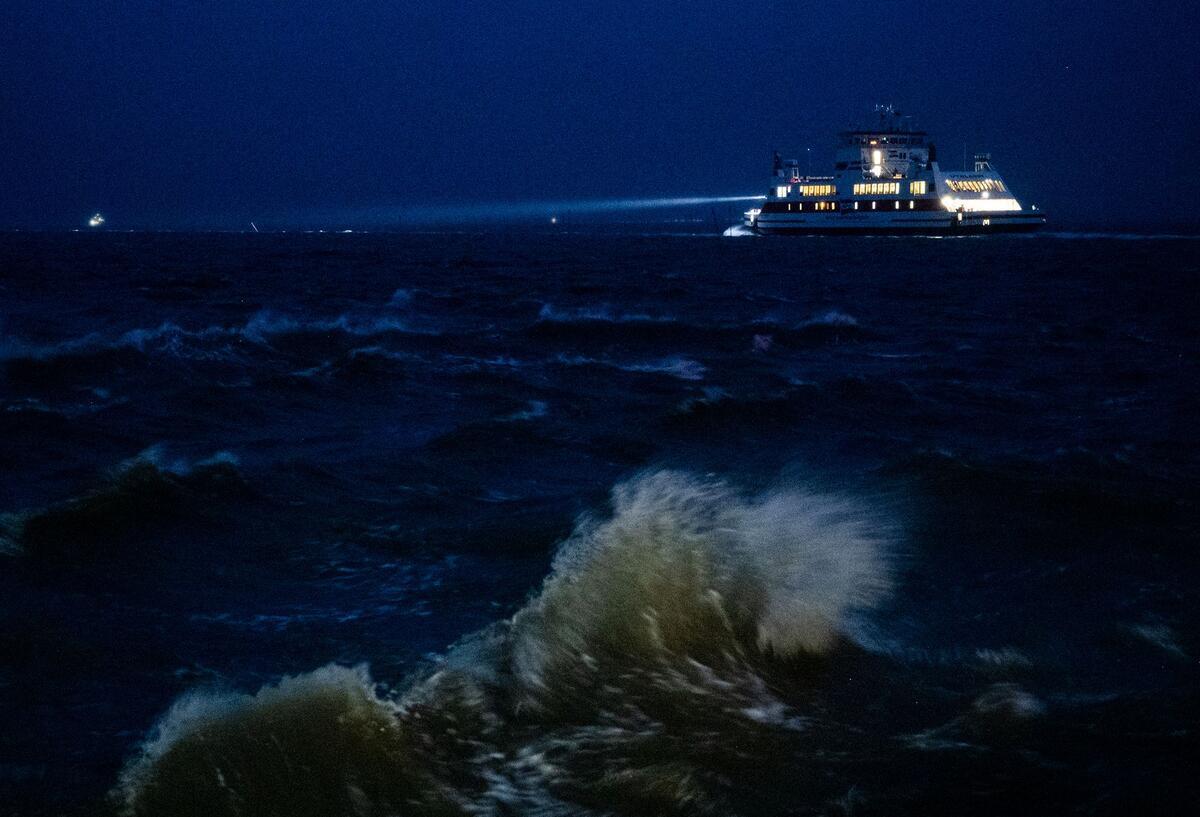 Ein Fährschiff fährt auf der aufgewühlten Nordsee in Richtung der Insel Föhr.