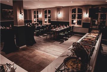 Restaurant mit eingedeckten Tischen und Buffet