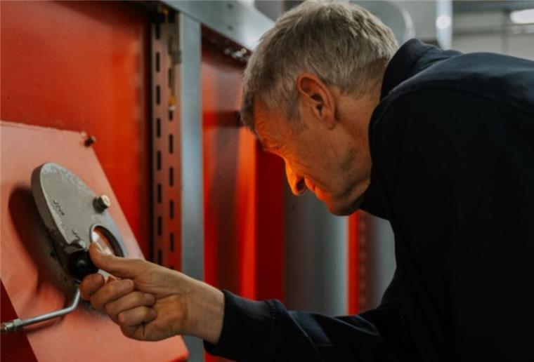 Ein Mann schaut in eine Verbrennungsanlage im Krematorium