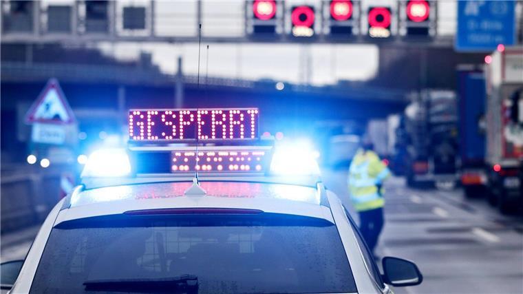 Auf einem Polizeifahrzeug leuchtet die Aufschrift „Gesperrt“.