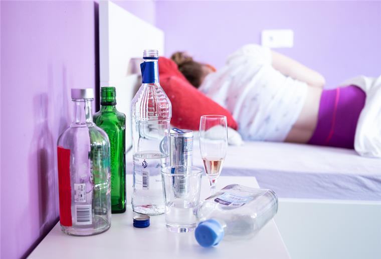 Bremen: Weniger Jugendliche mit Alkoholvergiftung im Krankenhaus Ein jugendliches Mädchen liegt in ihrem Bett, während auf ihrem Nachttisch Flaschen mit Alkohol sowie Gläser stehen.