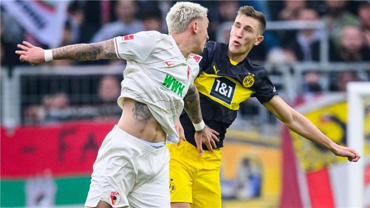 Sahins bittere Woche: Nächster BVB-Flop - „Müssen liefern“ Augsburgs Phillip Tietz (l) und Dortmunds Nico Schlotterbeck im Luftkampf.