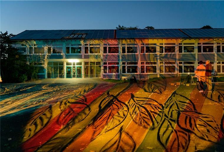 Aus der feinen Feder der Künstlerin Heide Duwe auf kleine „Dias“ gemalt, fällt riesiges Herbstlaub auf den Hof der Oberschule Geestemünde und auf die Fassaden ringsum. Foto: Masorat