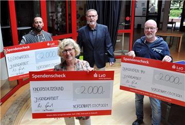 Ausgelassene Stimmung bei der Spendenübergabe: Yasin Güngör (links), Vorsitzender des TuS Einswarden, Anne Allmers, Vorsitzende des Kinderschutzbundes, und Peter Kleemann (rechts), Vorsitzender des Bürgervereins Friedrich-August-Hütte, freuen sich über je 2000 Euro, die Wilfried Fugel (3. von links) für die Vereine gespendet hat. Foto: Heilscher