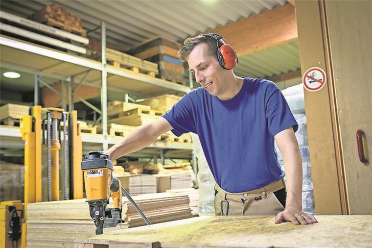 Kunden schätzen die hohe Qualität Ein Tischler bearbeitet Holz in einer Tischlerei.
