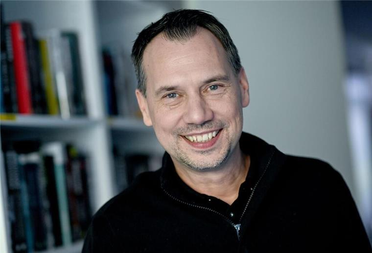 Autor Sebastian Fitzek vor einem Bücherregal.