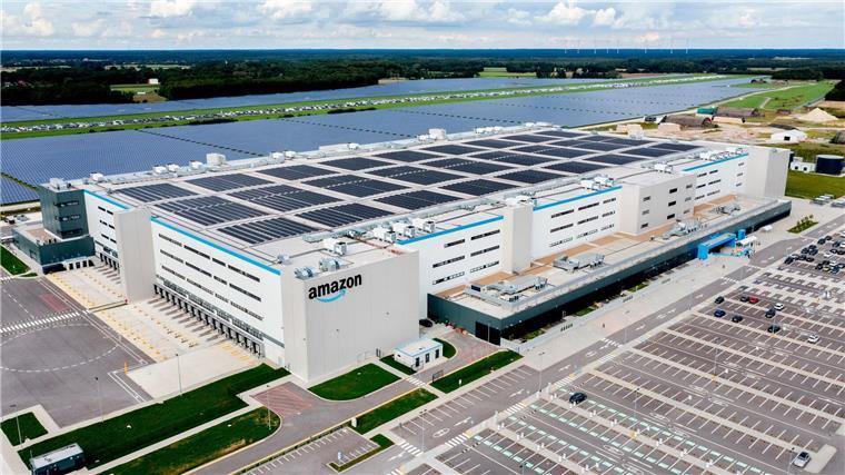 Neues Amazon-Logistikzentrum im Kreis Oldenburg eröffnet Autos stehen auf einem Parkplatz vor dem neuen Logistikzentrum von Amazon in Großenkneten.