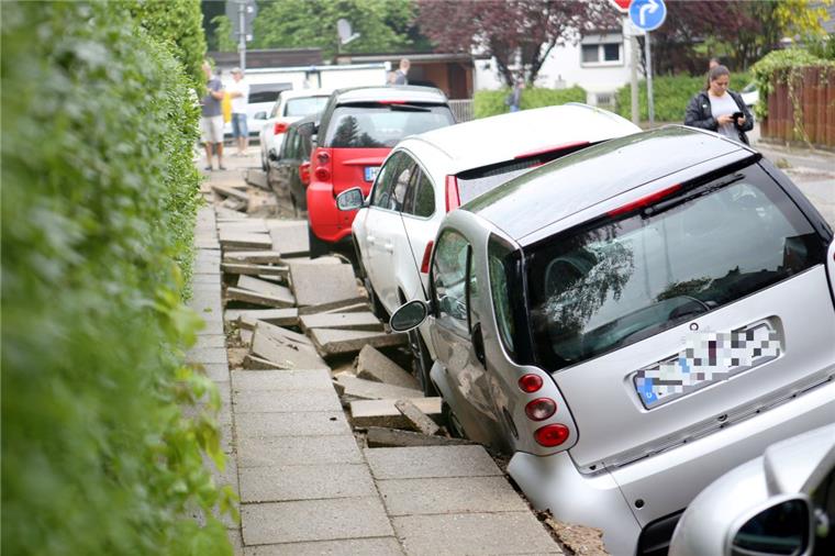 Nach dem heftigen Starkregen im Norden: Die Aufräumarbeiten beginnen Autos stehen nach einem Unwetter an einer unterspülten Straße in Hamburg-Bergedorf.