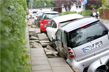 Autos stehen nach einem Unwetter an einer unterspülten Straße in Hamburg-Bergedorf. 