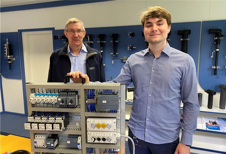 Azubi Roy Meyer (rechts) und Helmut Schmidt, Ausbildungsbetreuer bei NKT in Nordenham, zeigen Meyers Prüfungsmodell, bei dem er das elektronische Schaltmodell einer Milchpulver-Fabrik nachgebaut hat.