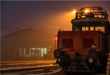 Bahnhof mit Güterzug bei nächtlicher Beleuchtung schafft unheimliche Stimmung