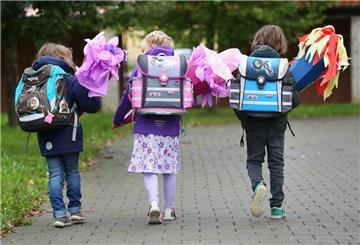 Die Erstklässler Josefine, Lena und David (l-r) sind mit ihren Schultüten auf dem Weg zur Einschulung in die 1. Klasse der Josef-Christian-Gemeinschaftsschule.