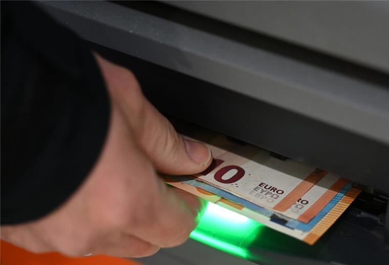 Ein Mann zieht Geldscheine aus dem Ausgabefach eines Geldautomaten. Bankkunden der Cash-Group gucken ab Juni in die Röhre: Sie können an weniger Punkten Bargeld abheben.