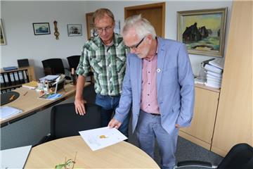 Bauamtsleiter Dieter Allers und Bürgermeister Ulf Voigts (von links) zeigen das Schreiben, das Grundstücksbesitzer erhalten haben: Für jede
Fläche muss angegeben werden, wohin das Regenwasser fließt. 