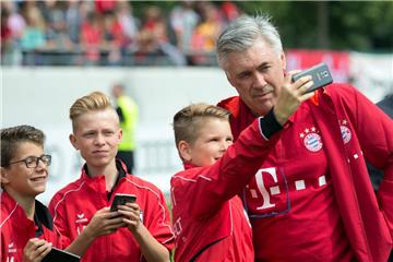 Bayern-Trainer Carlo Ancelotti lässt sich vor dem Spiel mit jungen Fans fotografieren. 