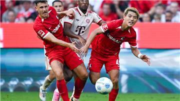 Bayerns Kingsley Coman (M) im Kampf mit zwei Freiburger Gegenspielern.