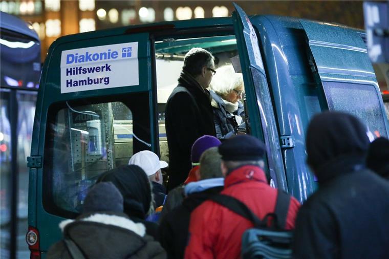 Mitternachtsbus versorgt seit 20 Jahren Obdachlose in Hamburg Bedürftige stehen in der Innenstadt von Hamburg bei der Ausgabe von Essen und heißen Getränken am Mitternachtsbus der Diakonie Hamburg. Seit 20 Jahren hilft der Diakonie-Mitternachtsbus obdachlosen Menschen auf Hamburgs Straßen mit Essen, heißen Getränken sowie Decken und Schlafsäcken.