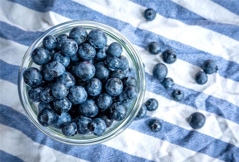 Die Heidelbeere, die Kim Kardashian des Obstkorbs Beeren statt Chips oder Nüsschen: Heidelbeeren, auch Blaubeeren genannt, liegen auf einem Esstisch und werden gern gesnackt.