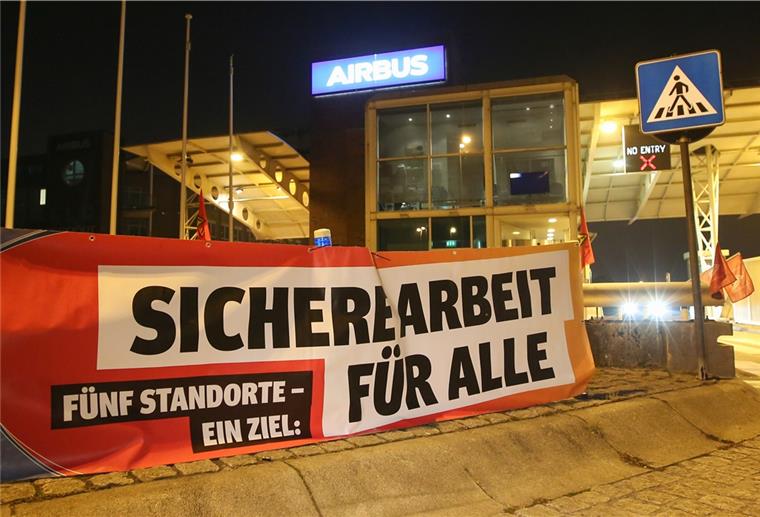 Ein Transparent mit der Aufschrift «Sichere Arbeit für Alle» hängt vor den Werkstoren des Flugzeugherstellers Airbus in Hamburg-Finkenwerder.