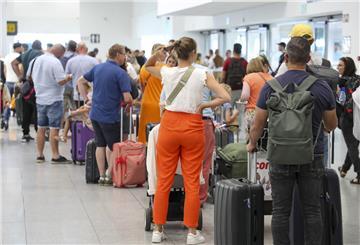 Passagiere warten in einer langen Schlange in der Abflughalle des Brüsseler Flughafens in Zaventem.