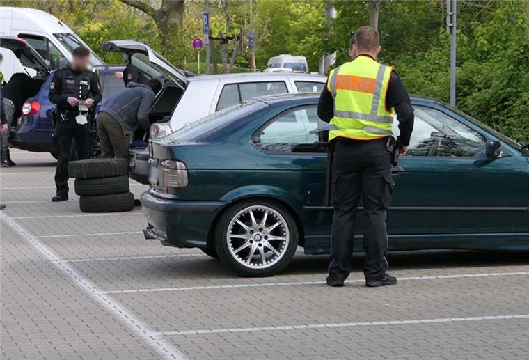 Verkehrsaktionstag: Polizei deckt mehrere Verstöße auf Polizisten kontrollieren mehrere Fahrzeuge auf einem Parkplatz.