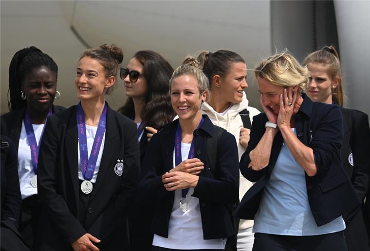 Bei der Ankunft am Frankfurter Flughafen: Ein Teil der Mannschaft mit Bundestrainerin Martina Voss-Tecklenburg (von rechts vorne), Svenja Huth und Felicitas Rauch steht auf dem Flughafen nach dem Aussteigen vor dem Flugzeug.