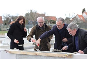 Bei der offiziellen Grundsteinlegung greifen (von links) Schulleiterin Sandra Pohl, Landrat Hermann Luttmann, Samtgemeindebürgermeister Frank Holle und der Ratsvorsitzende Rolf Struckmeyer zur Maurerkelle.