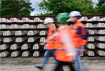 Baustellenbesucher gehen während der Generalsanierung der Bahnstrecke Hamburg - Berlin an neuen Schienen vorbei (Wischeffekt durch Langzeitbelichtung)